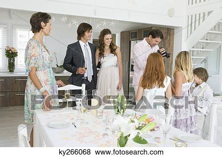 Stock Photo - Newlywed couple enjoying with guests in a party. Fotosearch