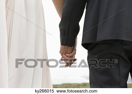 Stock Photography - Rear view of a couple holding hands. Fotosearch