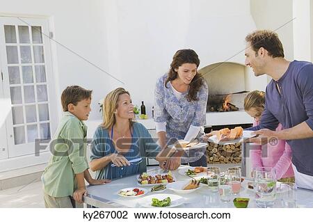 Stock Image - Family having breakfast at the dining table. Fotosearch