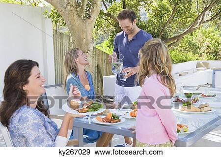 Stock Photo - Family having breakfast at the dining table. Fotosearch
