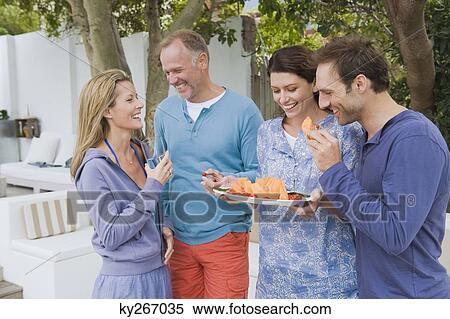 Four friends eating fruits and having fun View Large Photo Image Stock Photography - Four friends eating fruits and having fun. Fotosearch
