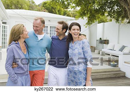 Four friends standing together and smiling View Large Photo Image Stock Image - Four friends standing together and smiling. Fotosearch