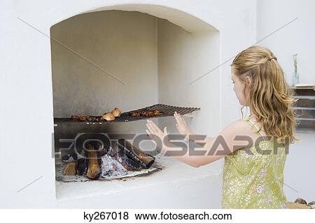 Girl cooking kebab in fireplace View Large Photo Image Stock Photo - Girl cooking kebab in fireplace. Fotosearch