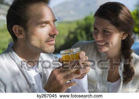 Man smelling marmalade with a woman smiling beside him View Large Photo Image Stock Photography - Man smelling marmalade with a woman smiling beside him. Fotosearch