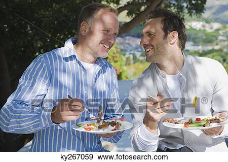 Two friends eating fruit salad View Large Photo Image Stock Photo - Two friends eating fruit salad. Fotosearch