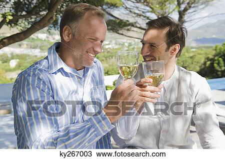 Two friends toasting with wine glasses View Large Photo Image Stock Image - Two friends toasting with wine glasses. Fotosearch