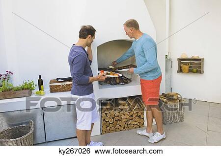 Two Men Cooking Kebab At Fireplace Stock Photograph Ky267026