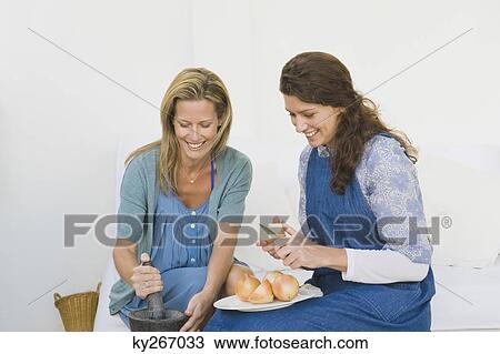 Two women preparing food at home View Large Photo Image Stock Image - Two women preparing food at home. Fotosearch
