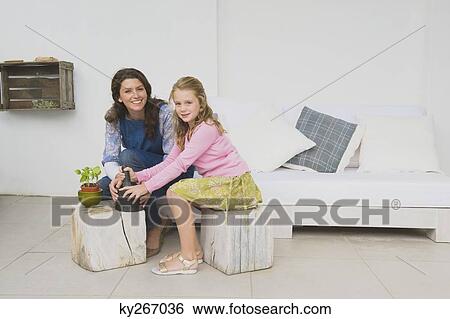 Stock Photograph - Woman and her daughter with mortar and pestle. Fotosearch