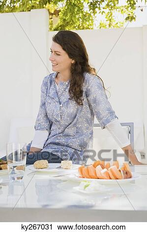 Woman having breakfast at a table View Large Photo Image Stock Image - Woman having breakfast at a table. Fotosearch