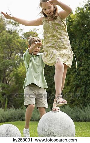 Boy and a girl playing in a garden View Large Photo Image Stock Image - Boy and a girl playing in a garden. Fotosearch