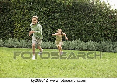 Boy and a girl playing in a garden View Large Photo Image Stock Image - Boy and a girl playing in a garden. Fotosearch