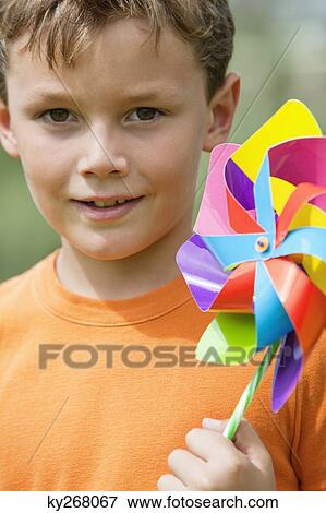 Boy holding a pinwheel View Large Photo Image Stock Photo - Boy holding a pinwheel. Fotosearch