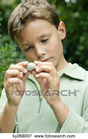Stock Photo - Boy holding a seashell. Fotosearch