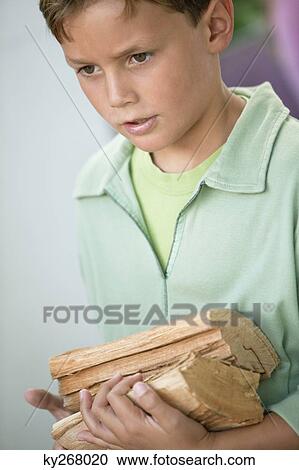 Boy holding firewood View Large Photo Image Stock Image - Boy holding firewood. Fotosearch