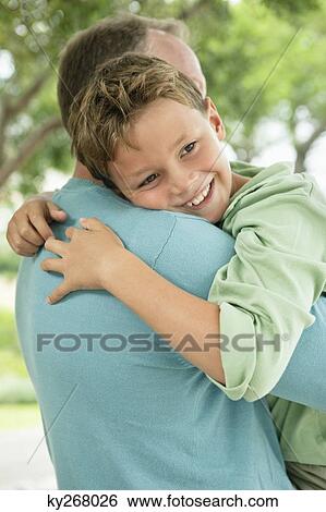 Boy hugging his father and smiling View Large Photo Image Stock Photograph - Boy hugging his father and smiling. Fotosearch