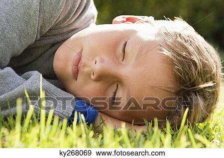 Boy napping on grass View Large Photo Image Stock Photo - Boy napping on grass. Fotosearch