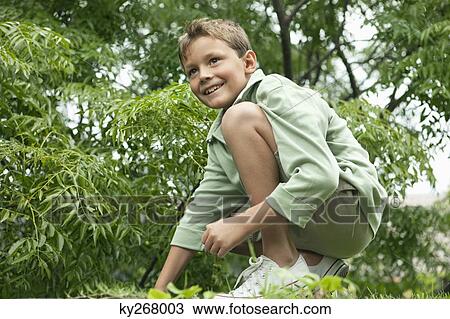Boy playing in a garden and smiling View Large Photo Image Stock Image - Boy playing in a garden and smiling. Fotosearch