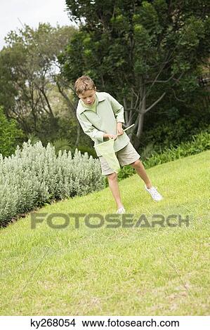 Boy playing with a butterfly net in a garden View Large Photo Image Picture - Boy playing with a butterfly net in a garden. Fotosearch