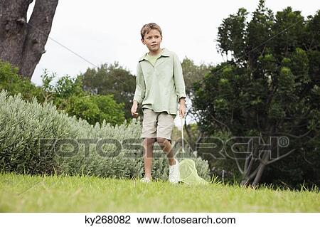 Boy playing with a butterfly net in a garden View Large Photo Image Stock Image - Boy playing with a butterfly net in a garden. Fotosearch