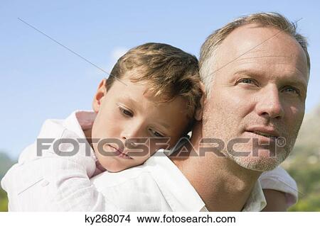 Picture - Boy riding piggyback on his father. Fotosearch