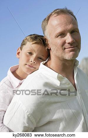 Boy riding piggyback on his father View Large Photo Image Stock Image - Boy riding piggyback on his father. Fotosearch