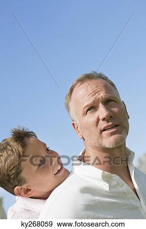 Boy riding piggyback on his father View Large Photo Image Stock Photo - Boy riding piggyback on his father. Fotosearch