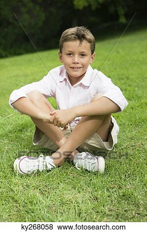 Stock Photo - Boy sitting in a park. Fotosearch