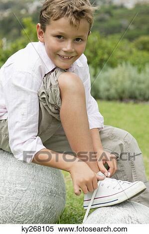 Boy tying his shoelaces View Large Photo Image Stock Photography - Boy tying his shoelaces. Fotosearch