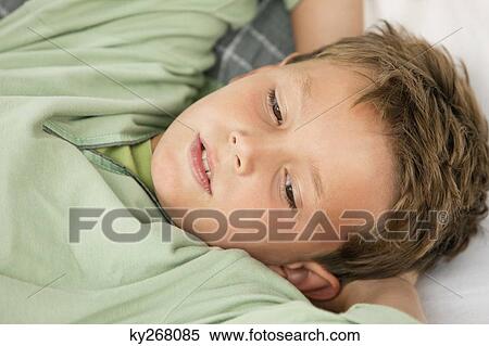 Close-up of a boy lying on the bed View Large Photo Image Stock Photography - Close-up of a boy lying on the bed. Fotosearch