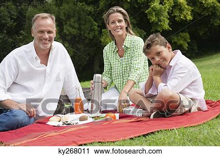 Family enjoying picnic in a park View Large Photo Image Stock Image - Family enjoying picnic in a park. Fotosearch