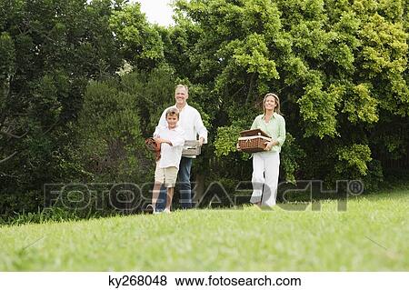 Stock Photo - Family enjoying picnic in a park. Fotosearch