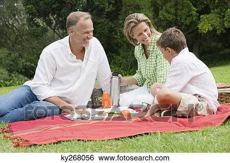 Family enjoying picnic in a park View Large Photo Image Stock Photograph - Family enjoying picnic in a park. Fotosearch
