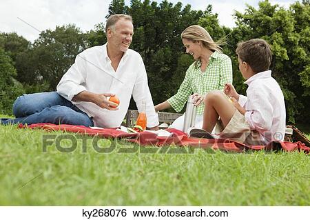 Family enjoying picnic in a park View Large Photo Image Stock Photograph - Family enjoying picnic in a park. Fotosearch