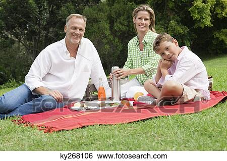 Stock Photograph - Family enjoying picnic in a park. Fotosearch