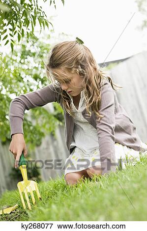 Girl gardening with a rake View Large Photo Image Stock Photo - Girl gardening with a rake. Fotosearch