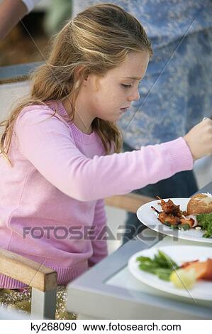 Girl having breakfast at a dining table View Large Photo Image Stock Image - Girl having breakfast at a dining table. Fotosearch