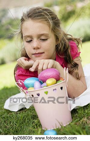 Girl looking at Easter eggs View Large Photo Image Stock Photography - Girl looking at Easter eggs. Fotosearch