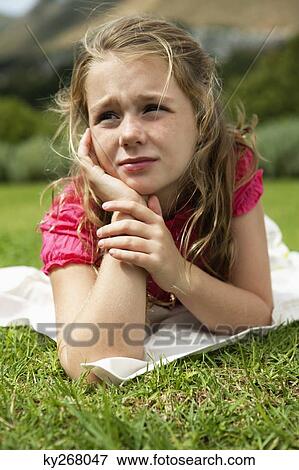 Girl lying on grass View Large Photo Image Stock Photo - Girl lying on grass. Fotosearch