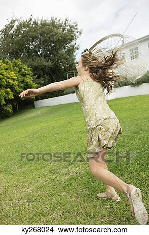 Girl playing with a butterfly net in a garden View Large Photo Image Picture - Girl playing with a butterfly net in a garden. Fotosearch