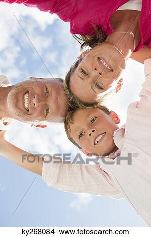 Low angle view of a family in huddle View Large Photo Image Picture - Low angle view of a family in huddle. Fotosearch