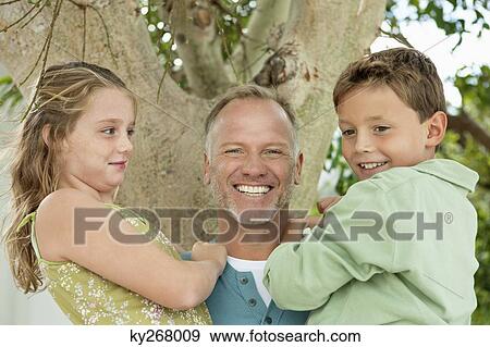 Man carrying his children View Large Photo Image Stock Photo - Man carrying his children. Fotosearch