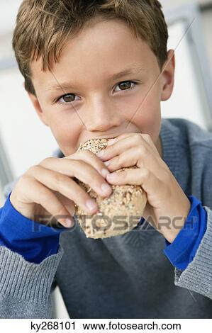 Portrait of a boy eating a bun View Large Photo Image Stock Image - Portrait of a boy eating a bun. Fotosearch