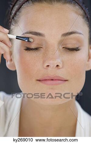 Close-up of a woman applying eye make-up View Large Photo Image Stock Image - Close-up of a woman applying eye make-up. Fotosearch