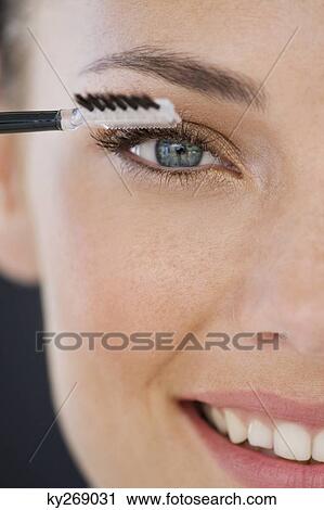 Portrait of a woman applying eye make-up View Large Photo Image Stock Image - Portrait of a woman applying eye make-up. Fotosearch