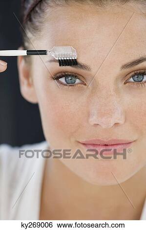 Portrait of a woman applying eye make-up View Large Photo Image Stock Photograph - Portrait of a woman applying eye make-up. Fotosearch