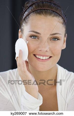 Portrait of a woman applying face powder View Large Photo Image Stock Photo - Portrait of a woman applying face powder. Fotosearch