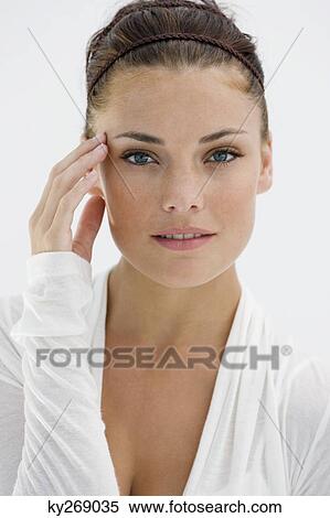 Portrait of a woman touching her temple View Large Photo Image Stock Photography - Portrait of a woman touching her temple. Fotosearch
