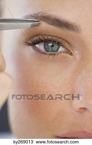 Portrait of a woman tweezing eyebrows View Large Photo Image Stock Image - Portrait of a woman tweezing eyebrows. Fotosearch