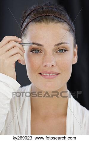 Portrait of a woman tweezing eyebrows View Large Photo Image Stock Image - Portrait of a woman tweezing eyebrows. Fotosearch